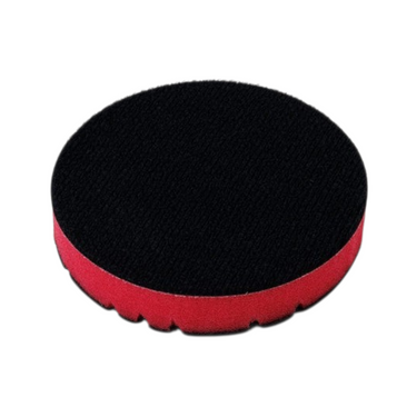 A black clay disc with red inner foam on a white background
